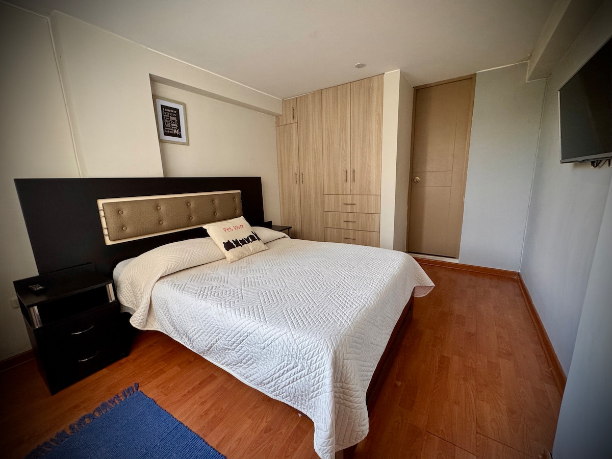 Hoofdslaapkamer met 2-zits bed, tv, badkamer