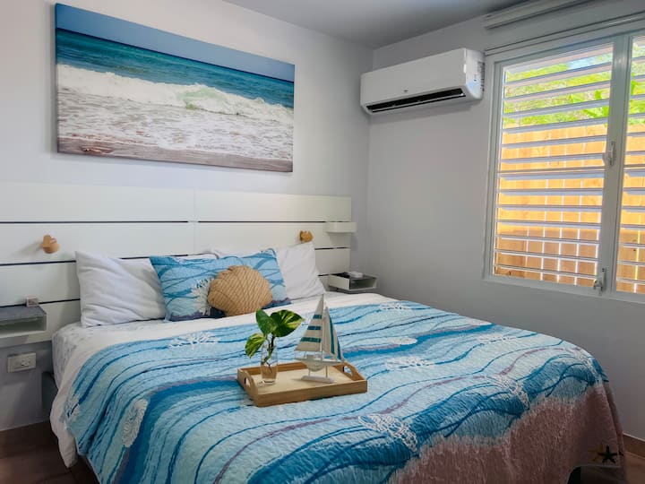 在这间舒适的海洋风格卧室中放松身心，享受配有柔软床上用品的舒适加大双人床。 享受宁静的氛围，沿海装饰、时尚镜子、床头阅读灯、空调和电视供您娱乐。