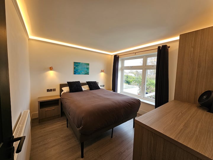 This upstairs  bedroom has fitted cupboards with hangers inside. It has a full length mirror attached to each cupboard.  There is also a hair dryer in the top shelf.

There are two reading lamps and a side table for your books and magazines.