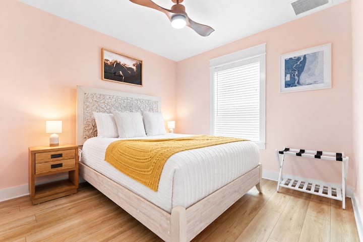 One of five, this first floor bedrooms features a carved white wood queen bed, comfy mattress and soft pink walls.