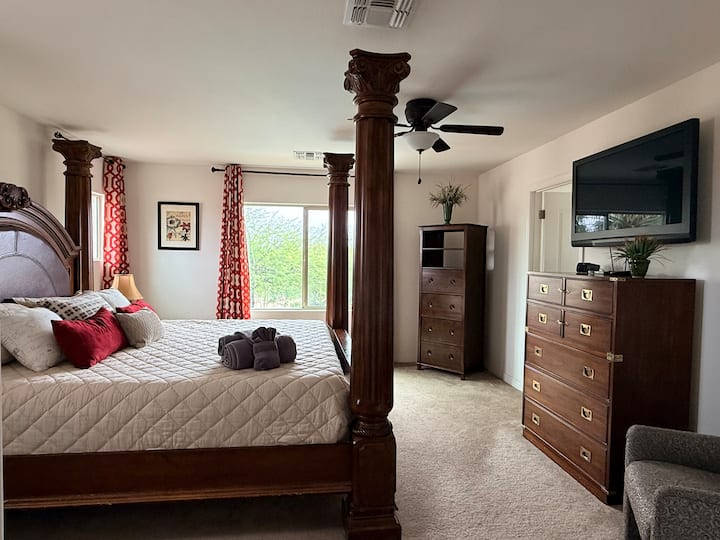 Primary bedroom is spacious with a stately king size bed and extra seating. Room includes Direct TV and all of the major Streaming Services.