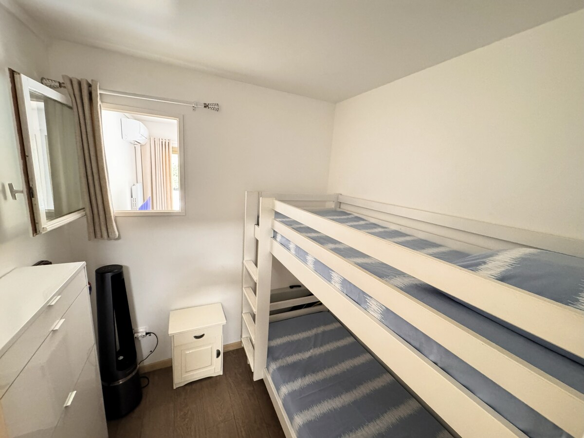 chumba cha kulala kilicho na vitanda vya ghorofa, dirisha dogo linaruhusu kiyoyozi cha sebule kupoza chumba cha kulala