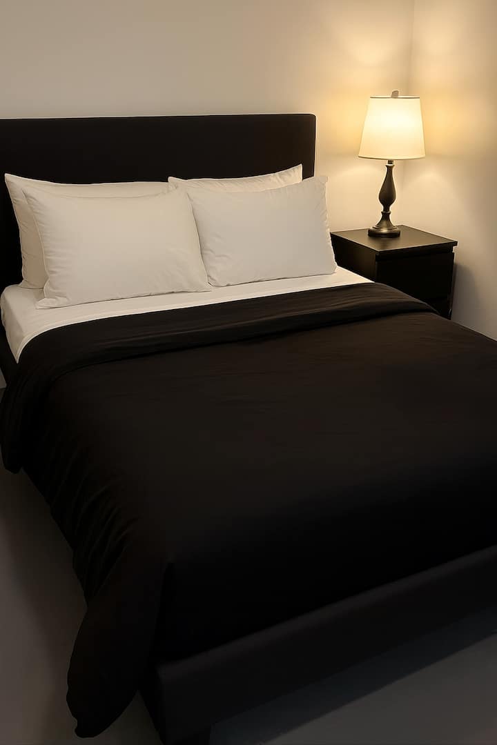 זהו חדר המרתף עם מיטת קווין סייז, טלוויזיה וחדר רחצה קטן.