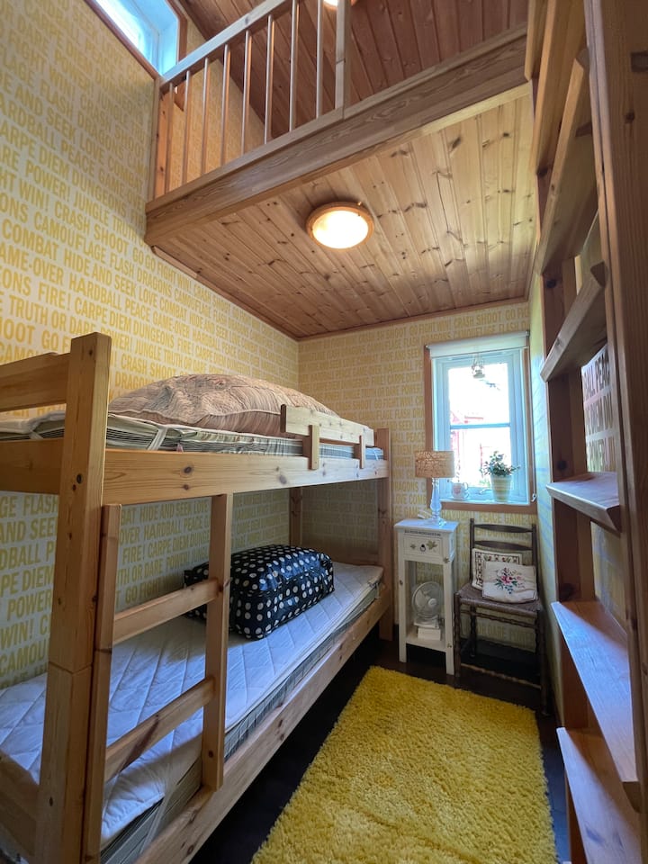 « La chambre jaune »
Lit superposé. Sur le lit, vous trouverez des sacs (un bleu et un avec des points) qui contiennent du linge de lit, des draps et des serviettes.