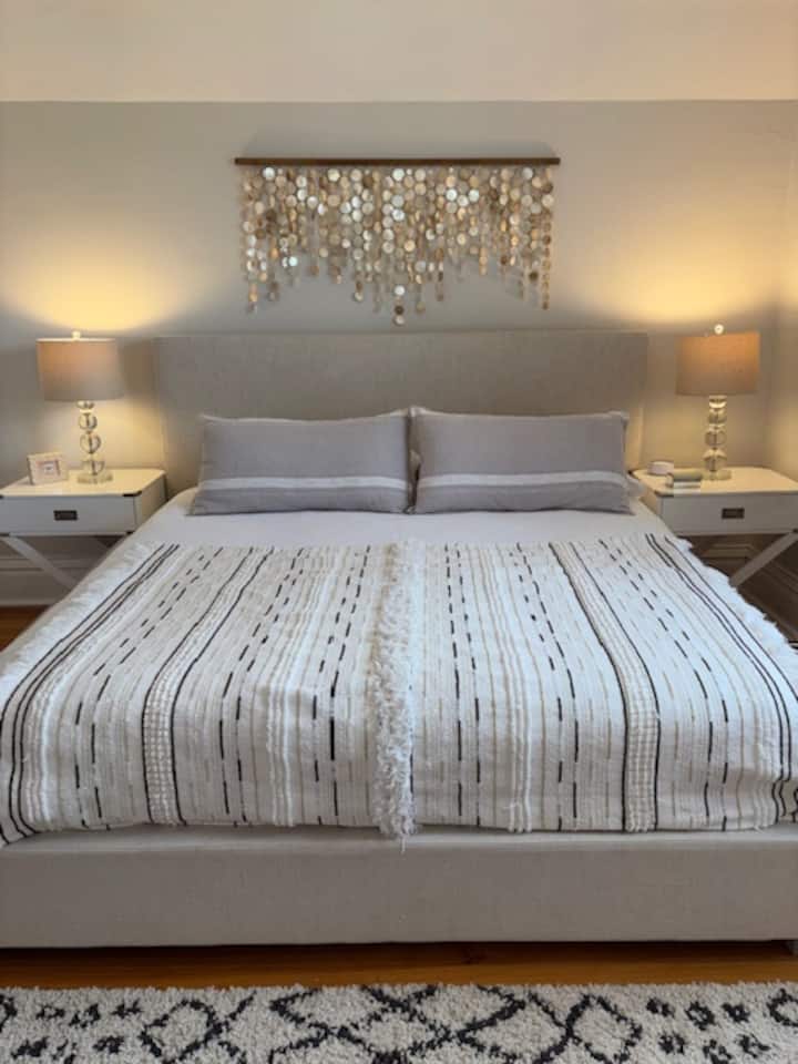 מסגרת מיטה מצופי לינן של Restoration Hardware, מזרן קינג סייז אורגני ומצעים יוקרתיים בחדר השינה הראשי. מכונת צלילים שתעשן אתכם לשינה.
