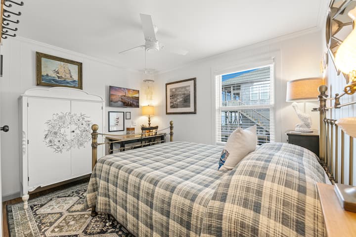 West-Full Bedroom with desk, ceiling fan, TV, and antique wardrobe.