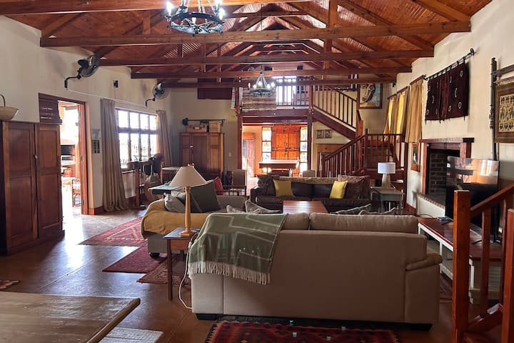 Просторен дневна соба со отворен план со поглед кон собата за игри и горниот кат.