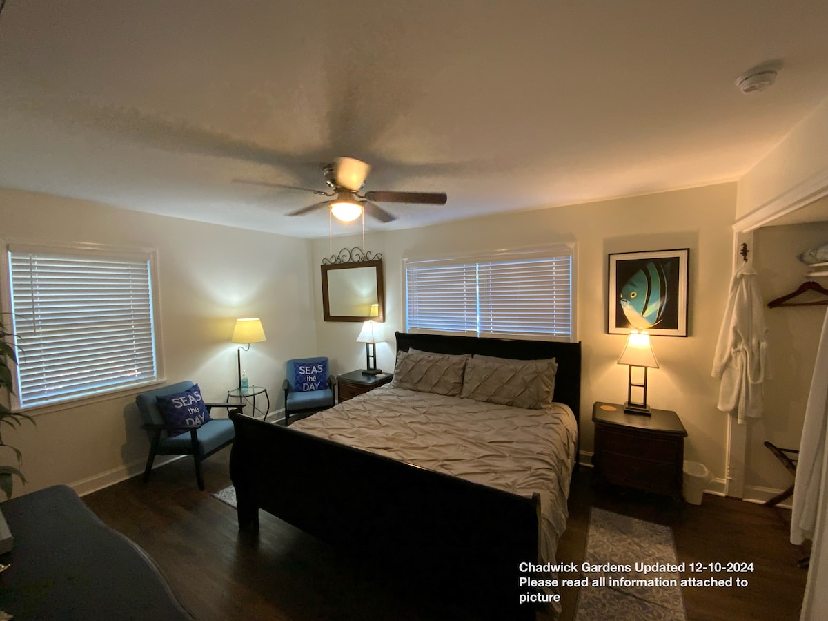 Master bedroom with king bed,  65” smart TV,  52” ceiling fan,  dresser, 2 sitting chairs, luggage racks, original art works.  