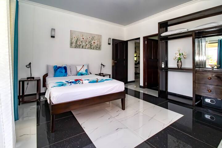 เตียงคู่และโต๊ะข้างเตียง 2 ตัวพร้อมโคมไฟในห้องนอนที่กว้างขวางและมีเครื่องปรับอากาศ
ห้องน้ำที่เชื่อมต่อเพื่อความเป็นส่วนตัวของคุณ

