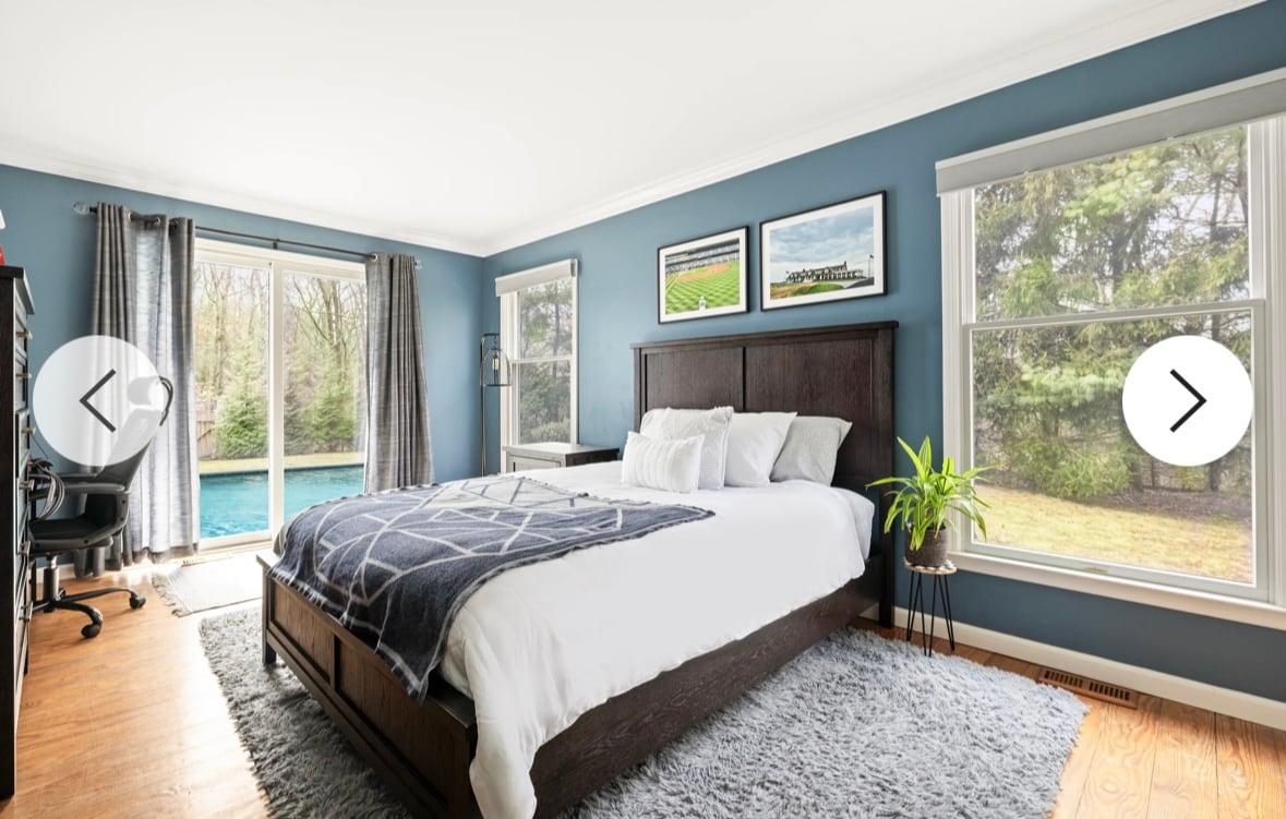 Dormitorio 1 en la planta baja, puertas correderas que conducen a la piscina, cama tamaño queen, amplio armario doble