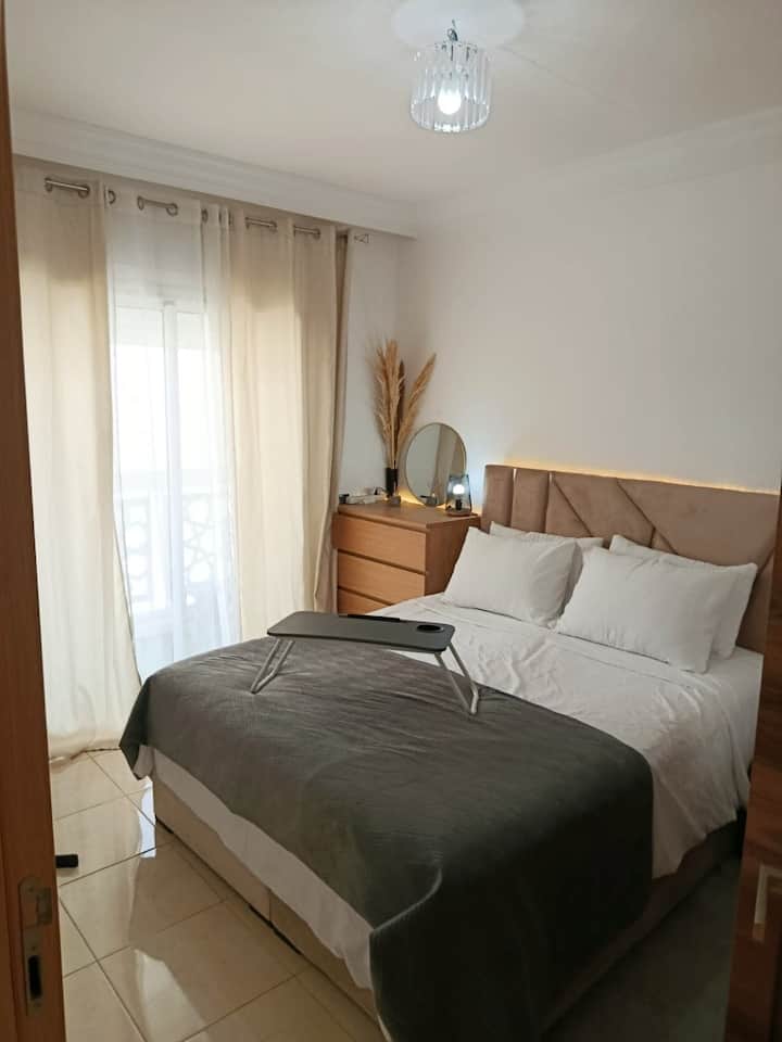 Habitación luminosa con cama tamaño queen, cómoda, ventilador y acceso a la terraza acristalada