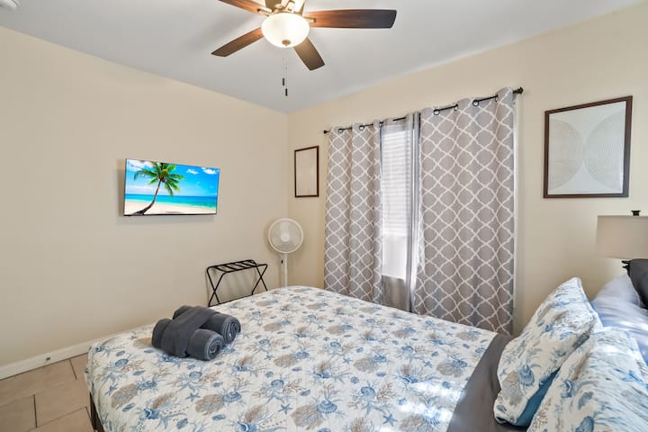 Cama tamaño queen con smart TV en la habitación. 