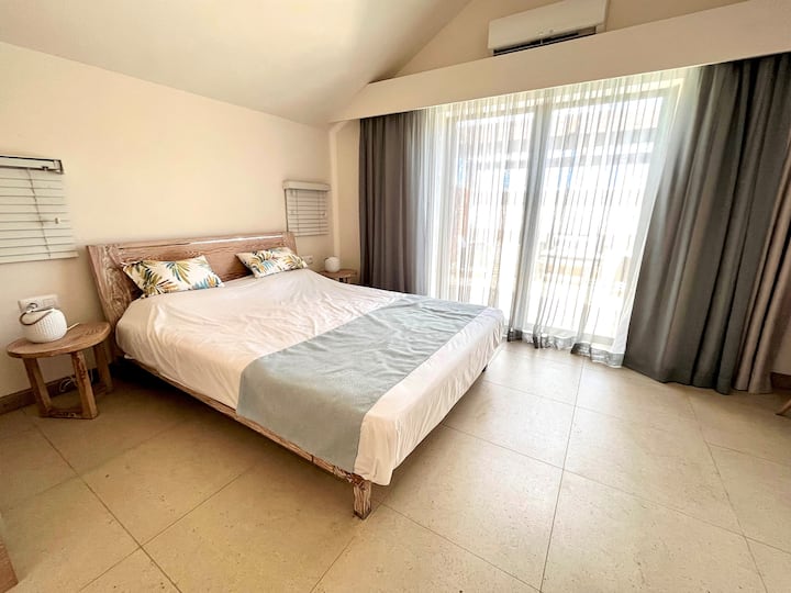 Habitación en el primer piso con espacio de almacenamiento, baño y aseo privados, y acceso a una hermosa terraza amueblada para disfrutar del exterior.