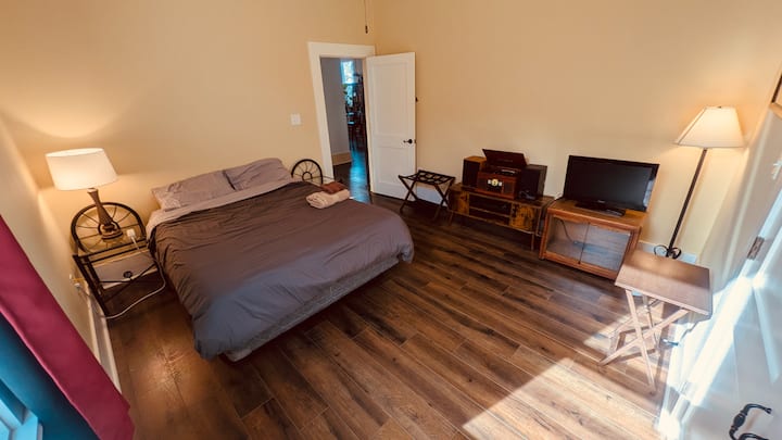 ゲスト用寝室1、写真2：クイーンベッド、レトロなアナログレコード/ラジオ/カセット/CD/Bluetoothプレーヤー、USB接続付きモニター、LEDオプションのカラー照明、天井ファン