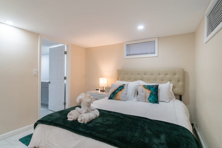 This sophisticated bedroom boasts an elegant tufted headboard, crisp luxury linens, and rich emerald accents. Perfect for a flawless, serene premium stay.