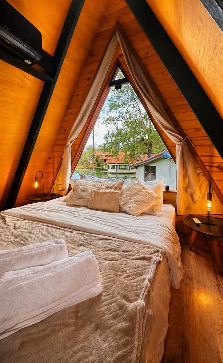 Dormir sob a arquitetura única do chalé, com vista para a natureza e iluminação aconchegante