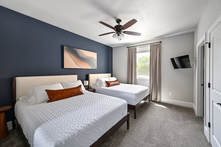 Suite principal con 2 camas tamaño queen, TV de pared y baño principal privado.