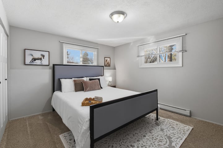 Comfortable California King Bed with featuring a plush bed, soft linens, and peaceful decor. Natural light and a quiet setting create a cozy retreat to relax, unwind, and enjoy a restful night’s sleep. Nightstand that have built in charging ports.