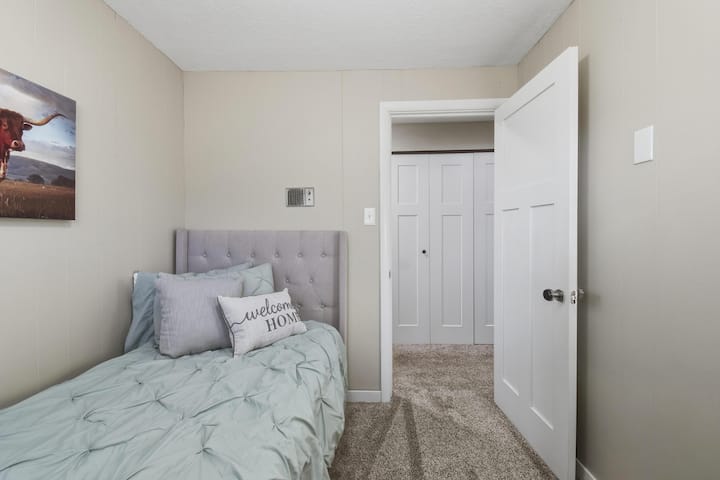 Cozy bedroom with a comfortable twin bed, soft linens, and warm western-inspired decor. A quiet, welcoming space perfect for relaxing and enjoying a peaceful night’s rest