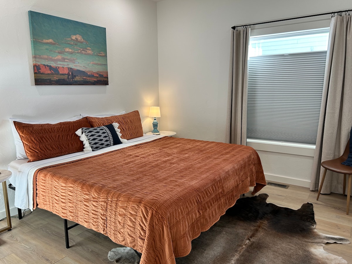 Veľká manželská posteľ. Z okna spálne je výhľad na zadný dvor nášho osobného bydliska. Okno je vybavené zatemňovacím tienidlom zhora nadol a zatemňovacími závesmi, aby sa zabezpečilo vaše súkromie.