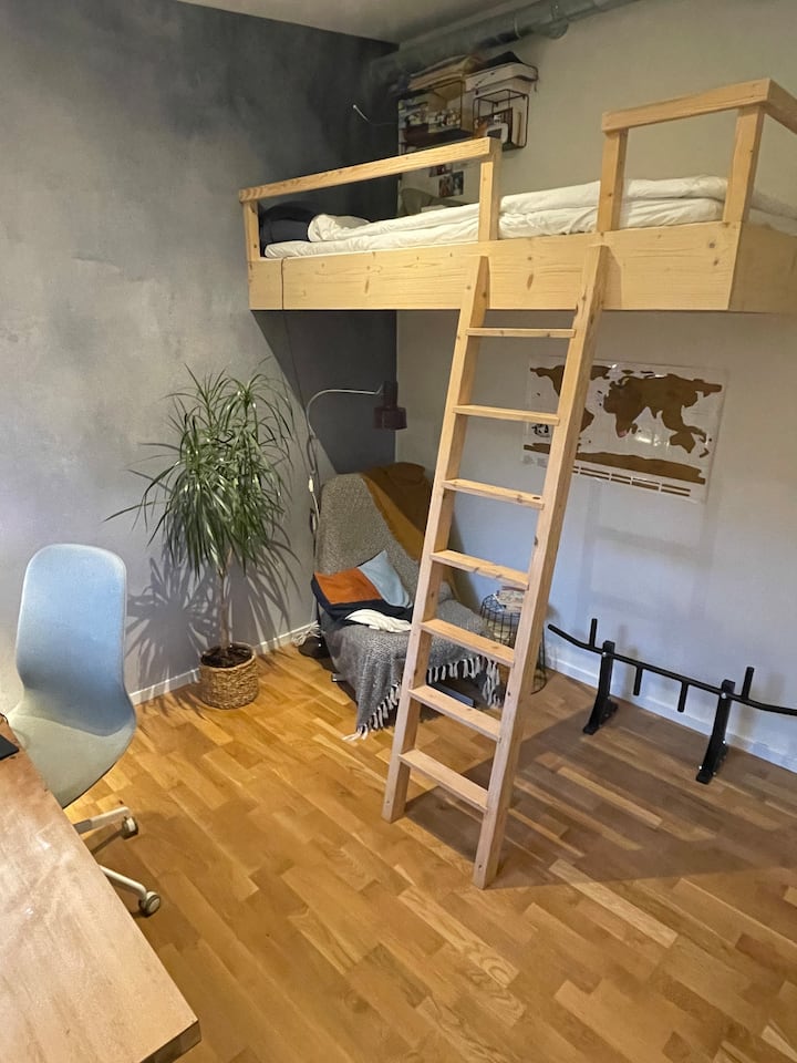 חדר שינה מאוורר עם תקרה גבוהה ומיטת לופט 