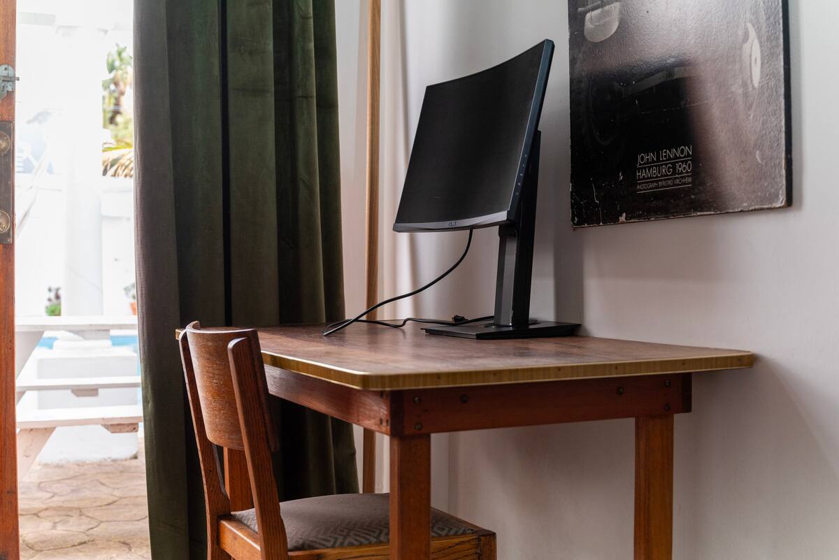 Desk and monitor workspace in the poolside room at Utopia co-living Cape Town