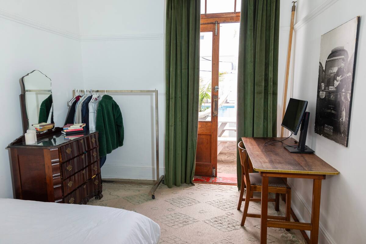 Poolside bedroom with balcony doors and dressing area at Utopia Cape Town