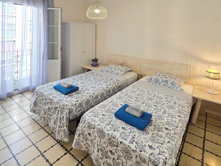 The first bedroom has two single beds that can be joined into a queen-size bed, depending on your preference. It opens onto a sunny balcony, perfect for morning coffee or an afternoon drink, and has classic green shutters for light sleepers.