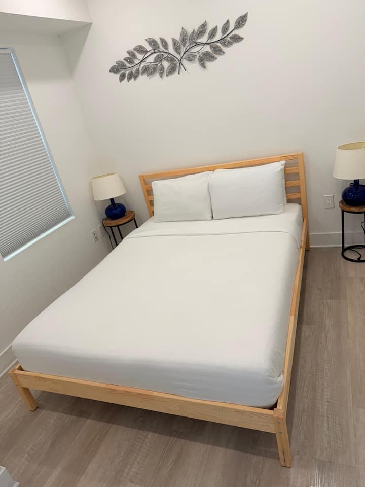 Chambre moderne avec cadre en bois, literie douce et décoration élégante pour un séjour reposant.