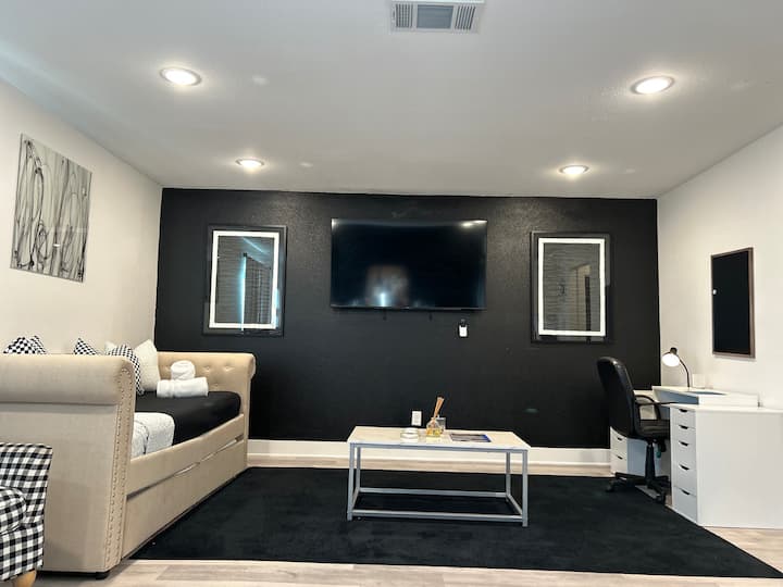 Una espaciosa área de concepto abierto con muebles modernos y una elegante configuración de entretenimiento, perfecta para reuniones y relajación.