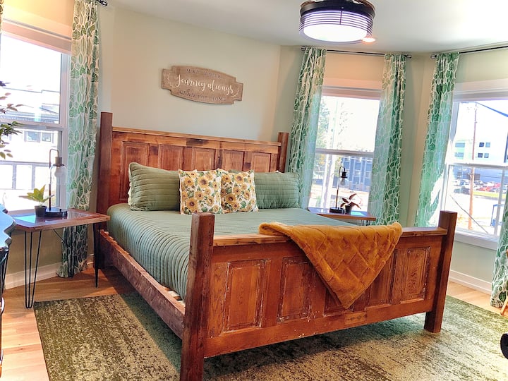 Დიდი ზომის საწოლი, დამატებითი საბნები და ბალიშები კარადაში.  Ფანჯრებს ფარდების უკან გაშავებული ჟალუზები აქვს.  Ასევე 65-დუიმიანი ტელევიზორი.