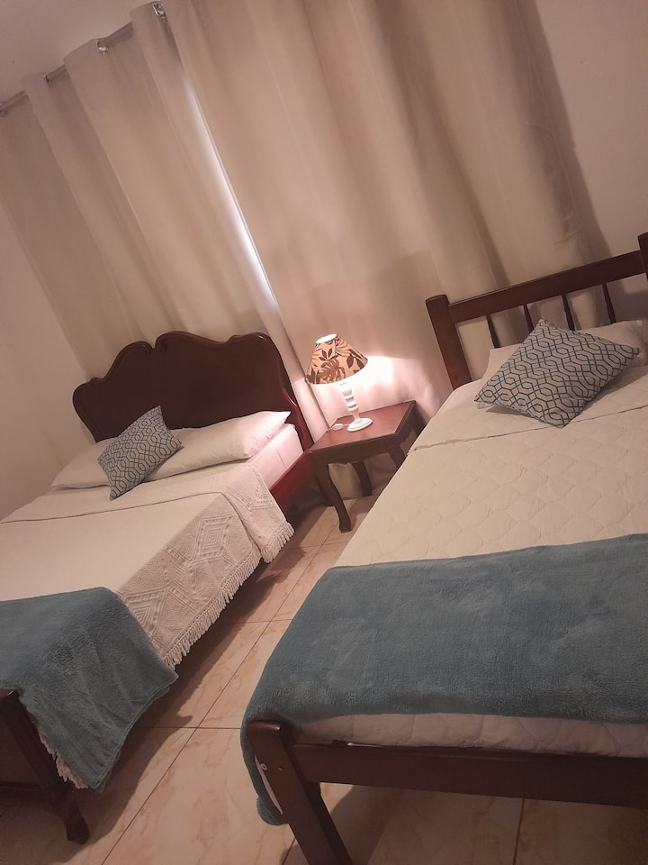 Chumba cha kulala kilicho na kitanda cha watu wawili na kitanda cha mtu mmoja, kilicho na kitanda na mashuka ya kuogea. 