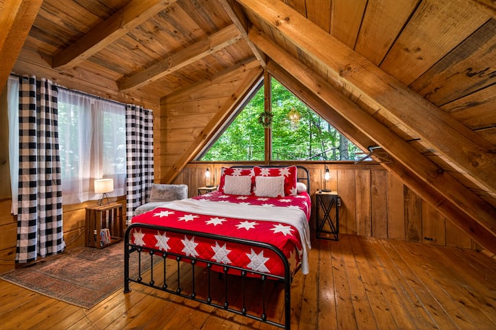 Cozy loft bedroom with forest views and rustic cabin charm