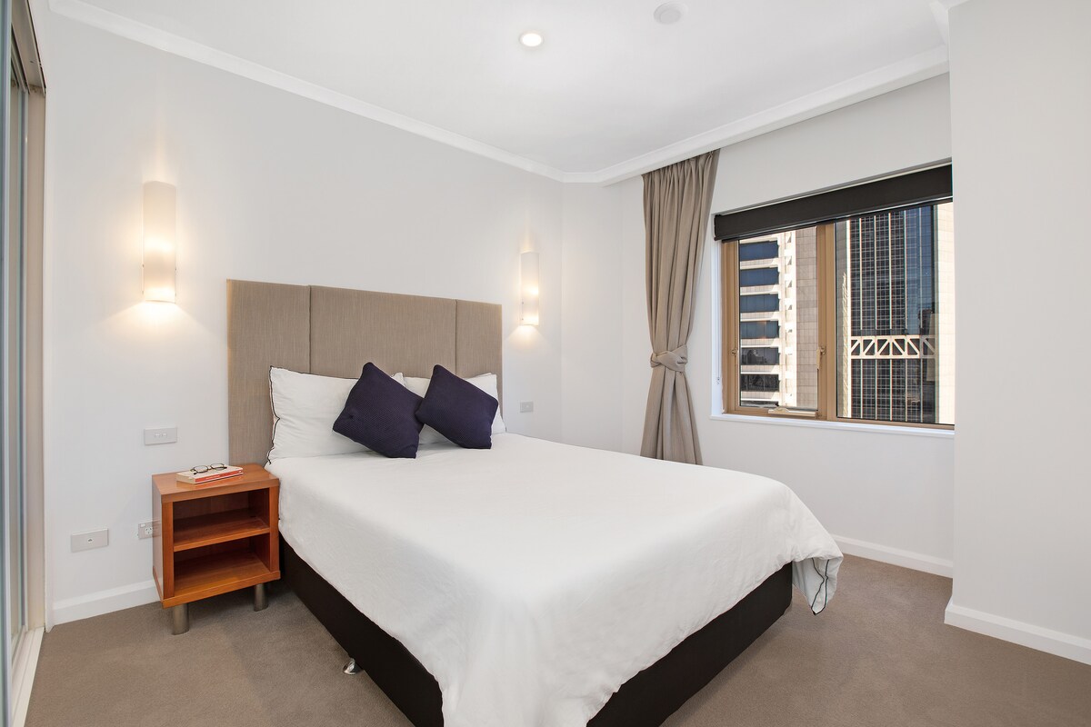 Cama tamaño king con amplio espacio en el armario y cajones en el dormitorio dedicado con vistas a la ciudad. Ropa de cama de hotel y persianas y cortinas opacas para que tengas un sueño cómodo. 