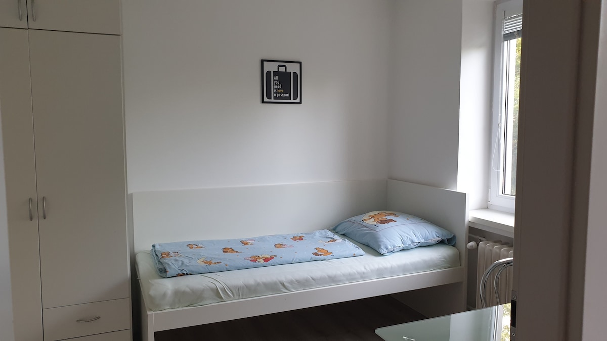 Soba s ormarom, krevetom 90 × 200 cm, radnim stolom i prozorom s pogledom na ulicu i park NTC.
Odličan izbor za 3 odrasle osobe ili dijete. 