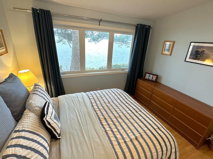 Primary Bedroom with Queen Bed also has a front row view of the water.  Luggage racks available in closet. Plenty of closet and drawer space. Blackout curtains.