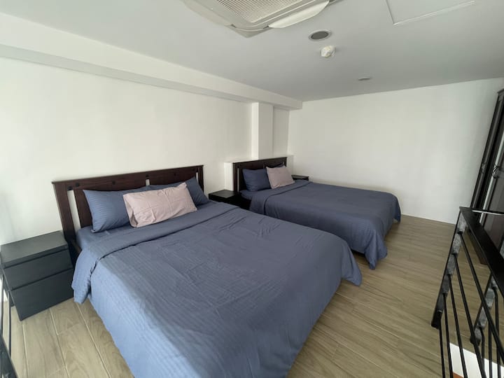 เตียงควีนไซส์ที่สบาย 2 เตียงพร้อมลิ้นชักโต๊ะข้างเตียง 2 ตู้บนห้องนอนลอฟท์
