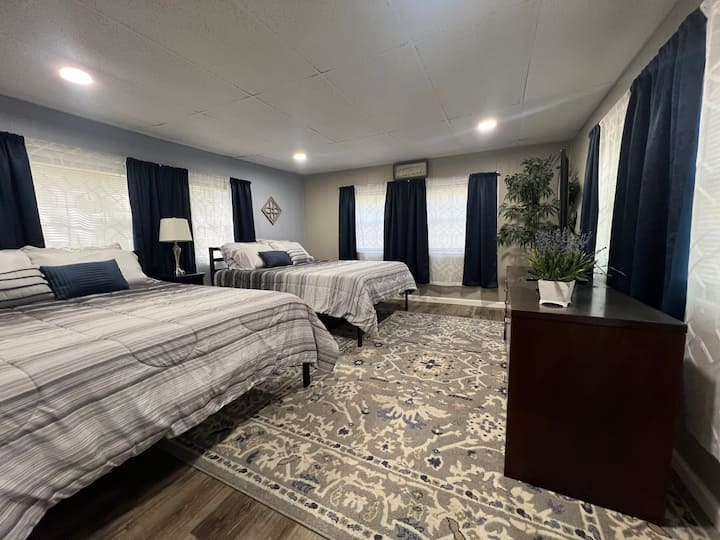 2 cozy queen beds. Large room that sleeps 4. TV with FireStick. Tower fan and full length mirror. Lots of windows for natural light with black out curtains for sleeping in or afternoon naps. 