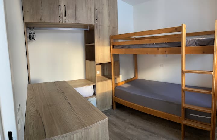 Спална соба со кревети на спрат, гардеробер со 3 фиоки и доволно простор за складирање. 
Имате вградена закачалка за облека и закачалки за лесно чување на јакните и капутите.