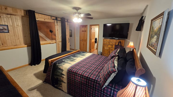 Loft master BR has own walk-in closet, full bath with shower, smart TV, two windows, Queen bed and privacy barn door with curtained view over living room below.  Sleigh bed accompaned by two dressers and two night stands.