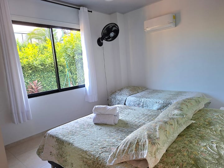 Rum med luftkonditionering, fläkt, gardin, garderob och mörkläggning. Med utsikt över trädgården. Det ligger på bottenvåningen i en stuga i Santa Marta, det har en dubbelsäng och en enkelsäng. Närmaste strand är Bello Horizonte bara 7 minuter bort.