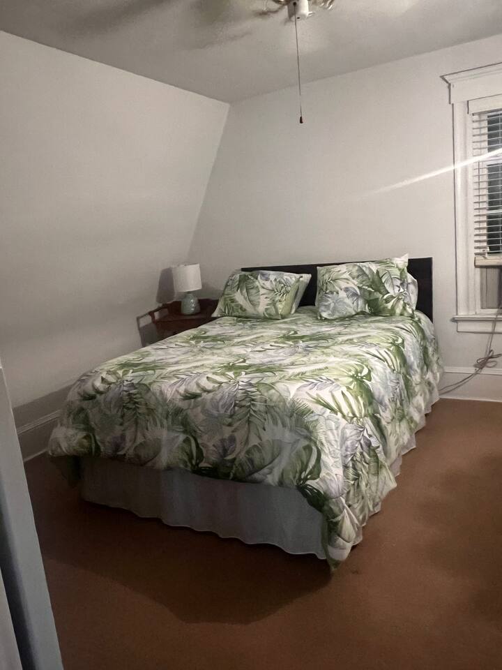 Lit queen size, ventilateur de plafond et climatiseur de fenêtre.
Commode du placard
avec miroir
Stand de nuit avec lumière