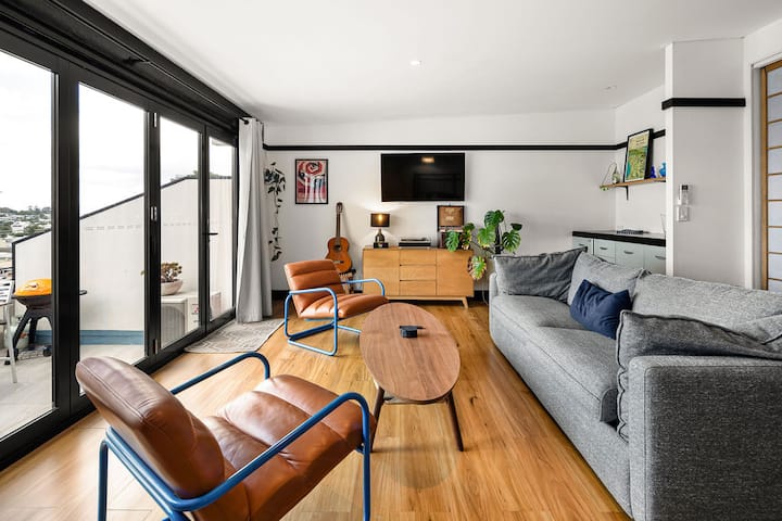 The third level breakout area has retro leather armchairs, a large comfy sofa that is also a queen size sofa bed, guitar, record player, TV, kitchenette, and bifold sliding doors that give you amazing views. This floor has a great vibe.