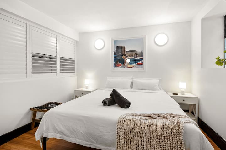 Bright, clean, and hotel-crisp. Bedroom 3 is on the second level and has a king bed, shutters with views into the ground level, along with build in wardrobes and full body mirrors.