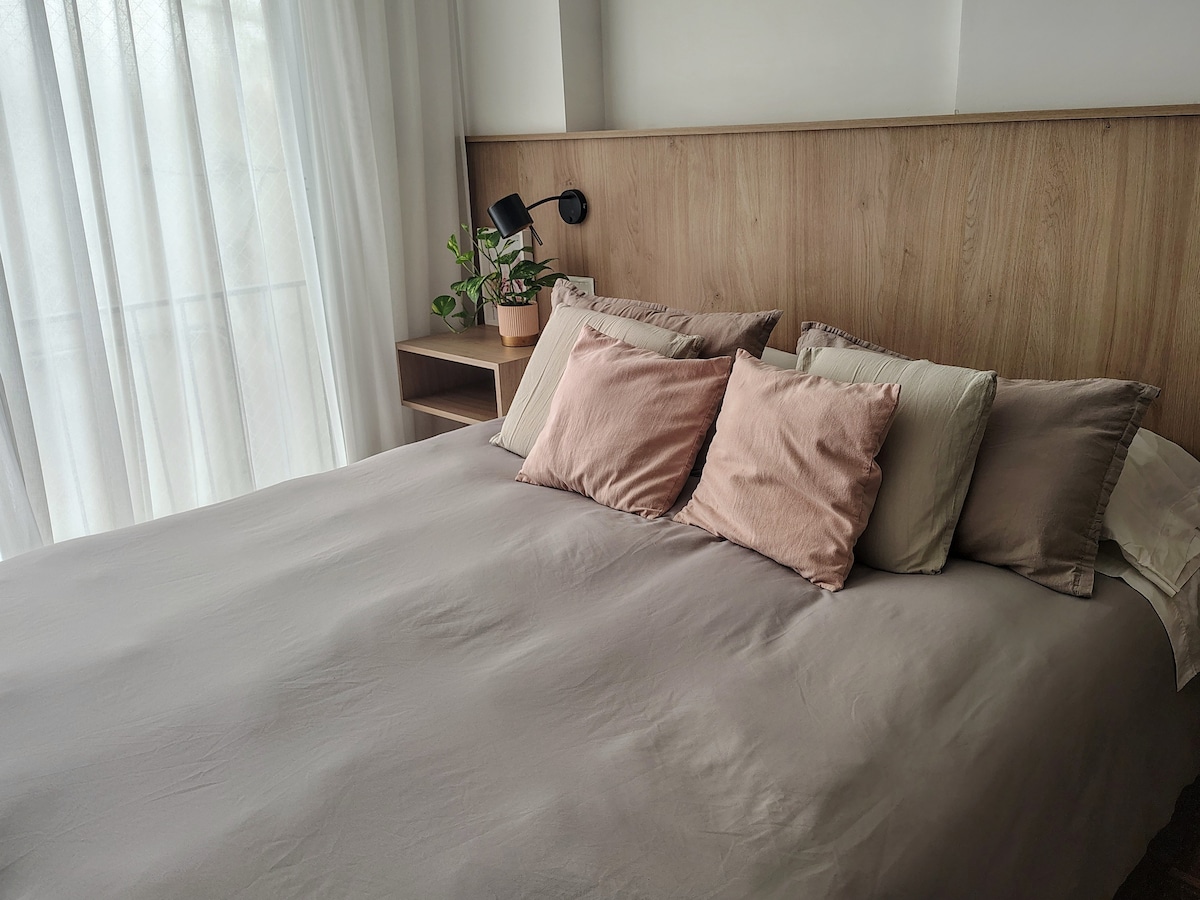 Cama queen con doble almohada y almohadones 