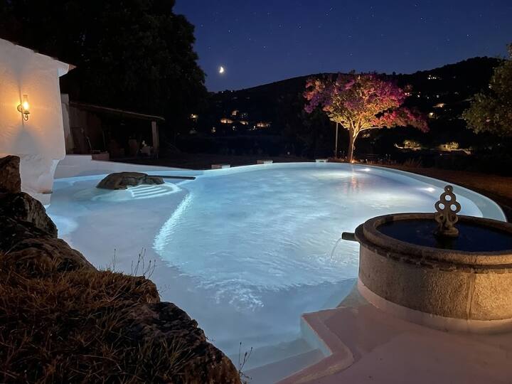 Piscina iluminada ao anoitecer, com vista sobre a paisagem. Partilhada por todos os hóspedes.