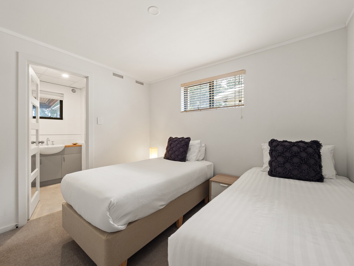 Chumba hiki kina vitanda viwili vya mtu mmoja, kinachofaa kwa wageni, na bafu la chumbani lililo karibu.