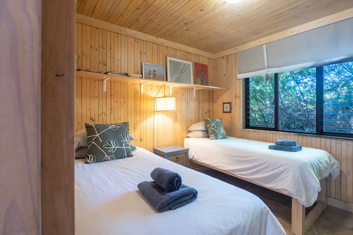 Tercer dormitorio en el nivel superior. Dos camas individuales con sábanas de algodón.