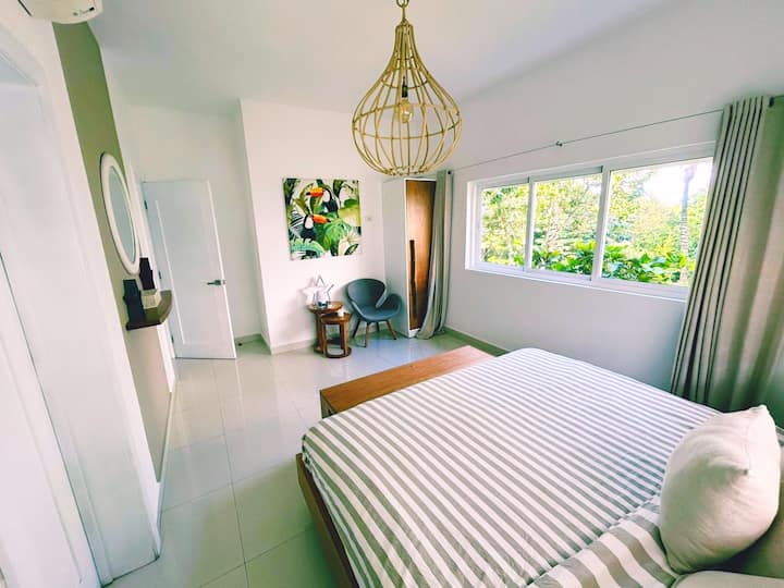 Hoofdslaapkamer met een kingsize bed en uitzicht op de natuur. Gasten hebben voldoende planken en hangrekken voor je bezittingen. 