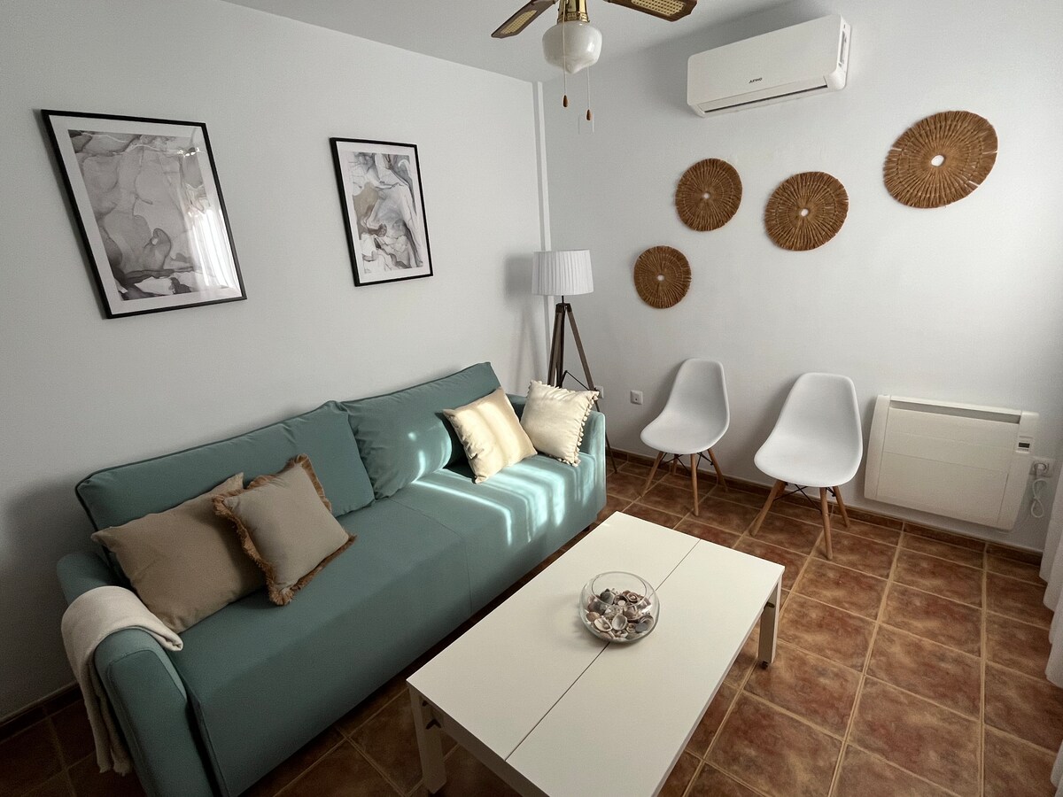 Proširivi kauč na razvlačenje, klima-uređaj s grijanjem na hladnu pumpu, plavi toplinski radijatori i stropni ventilator.